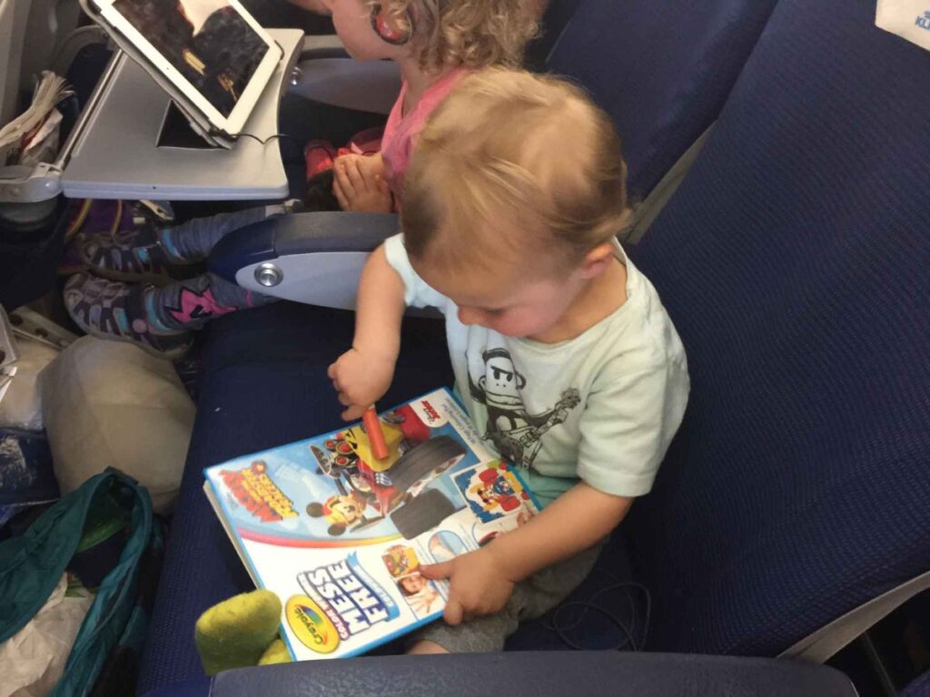 a toddler plays with a Crayola Color Wonder book on a plane to Norway.
