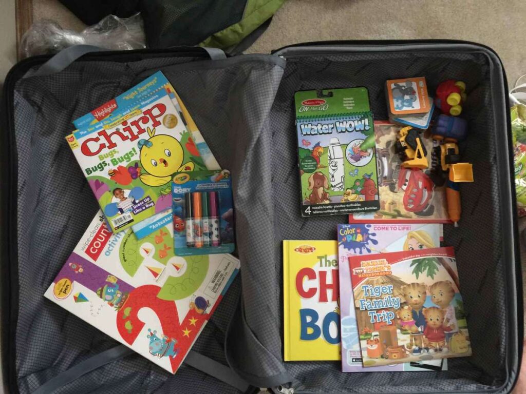 Our suitcase holing the travel activities we brought for our toddler on a our family trip to Norway,