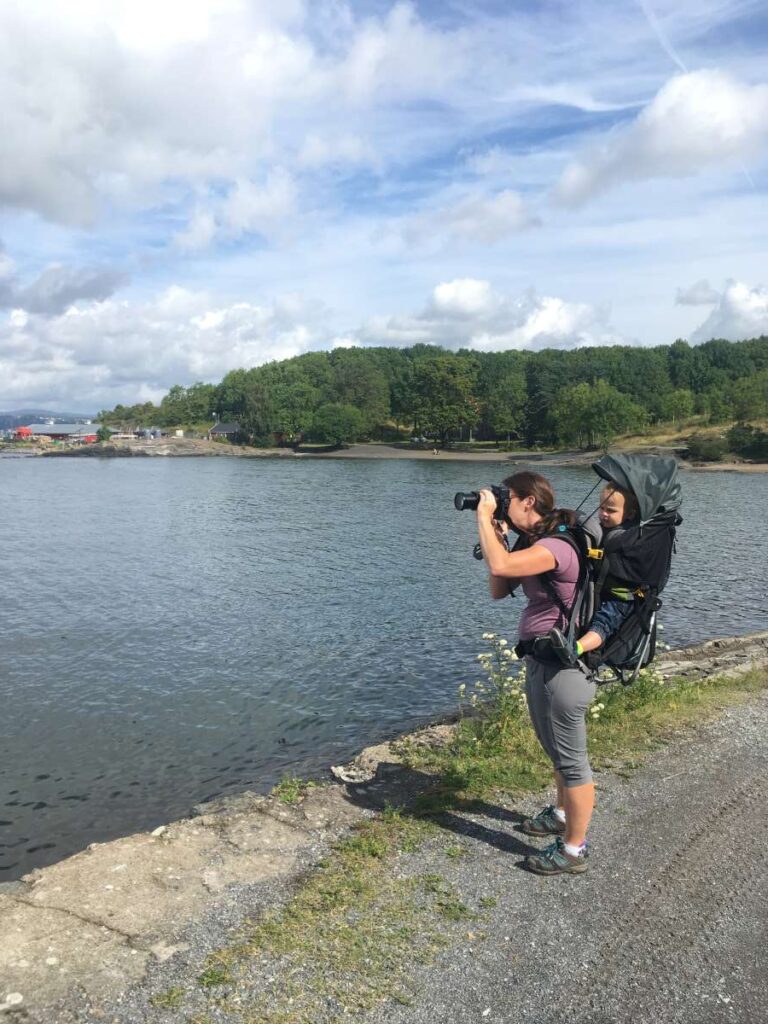 Celine Brewer, owner of FamilyCanTravel.com, takes pictures with a DSLR camera while traveling to Norway with kids.