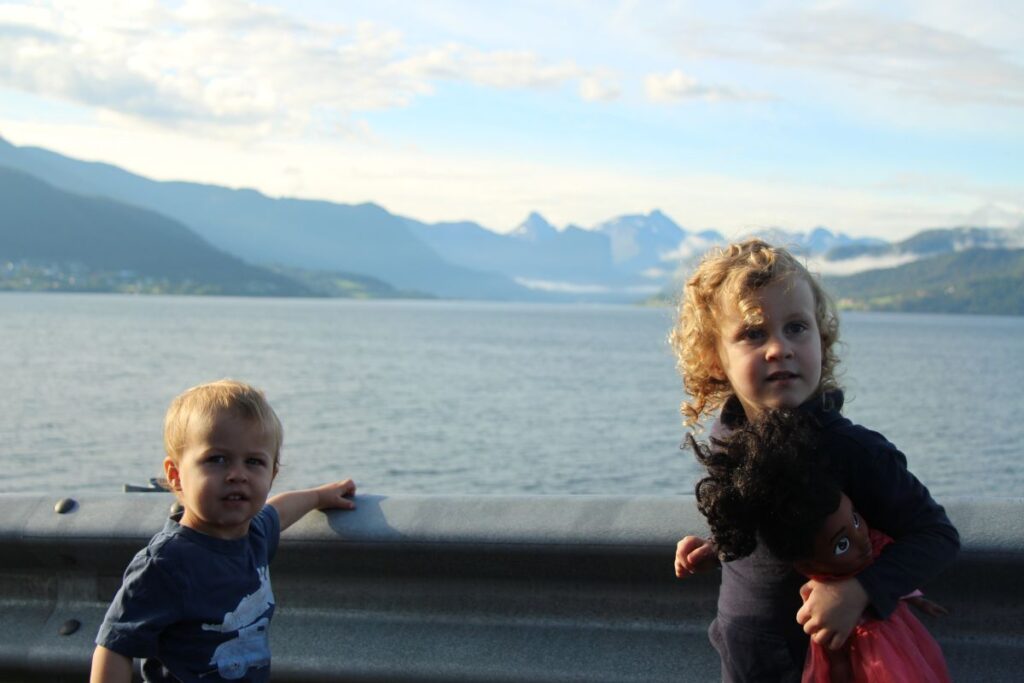 Two small kids on a family trip to Norway wear t-shirts on a sunny day in August.