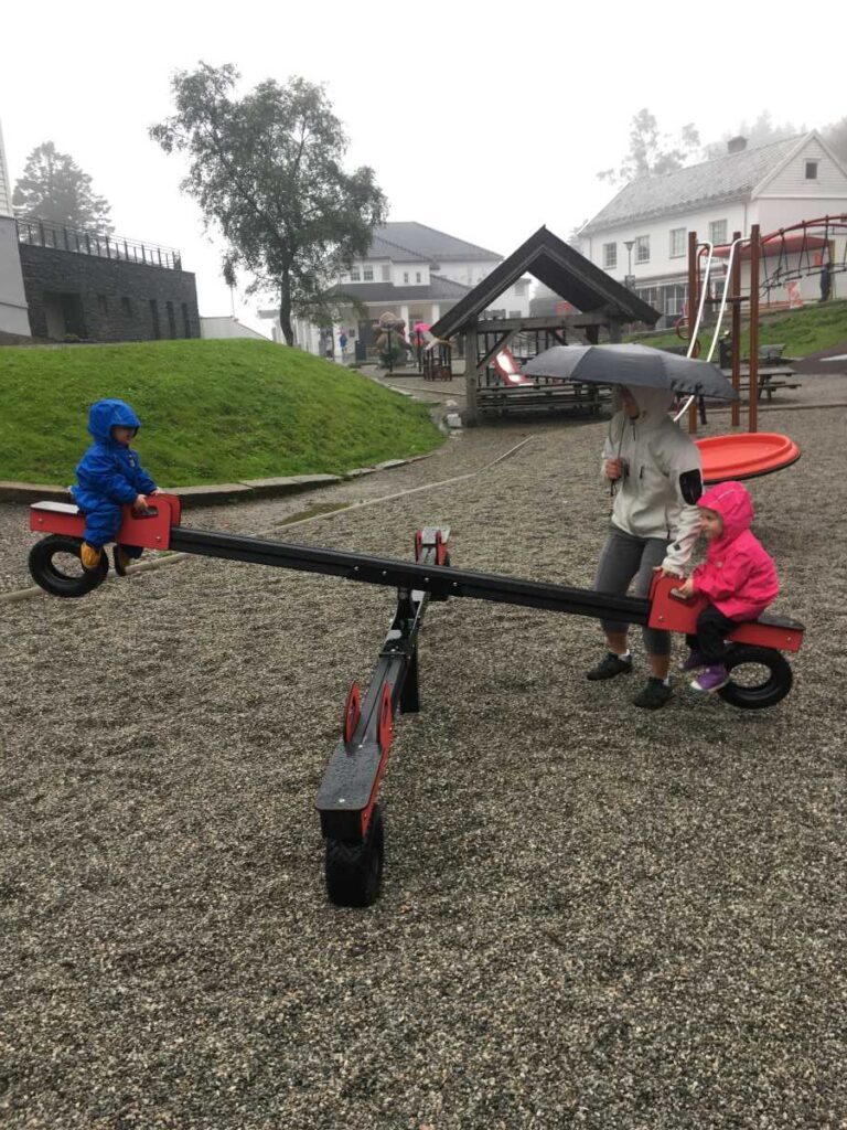 The Brewer kids, from the Family Can Travel blog, wear rain gear at a playground in Bergen in August.