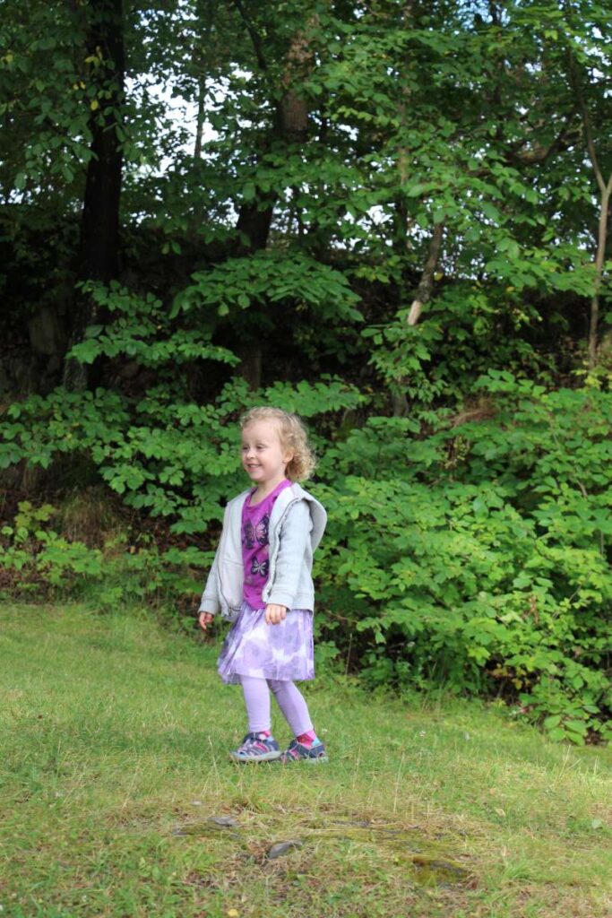 a 4-year old girl dresses warmly on a cool summer day on a family trip to Norway.