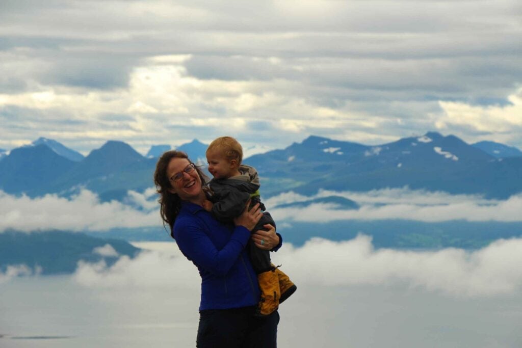 Celine Brewer, owner of FamilyCanTravel.com, wears a warm, long sleeve shirt while hiking with her kids on a trip to Norway with kids.