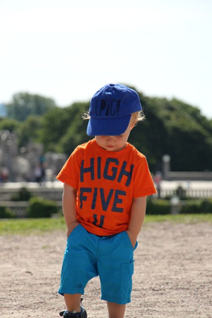 a toddler is dressed for warm summer weather on a family trip to Norway.