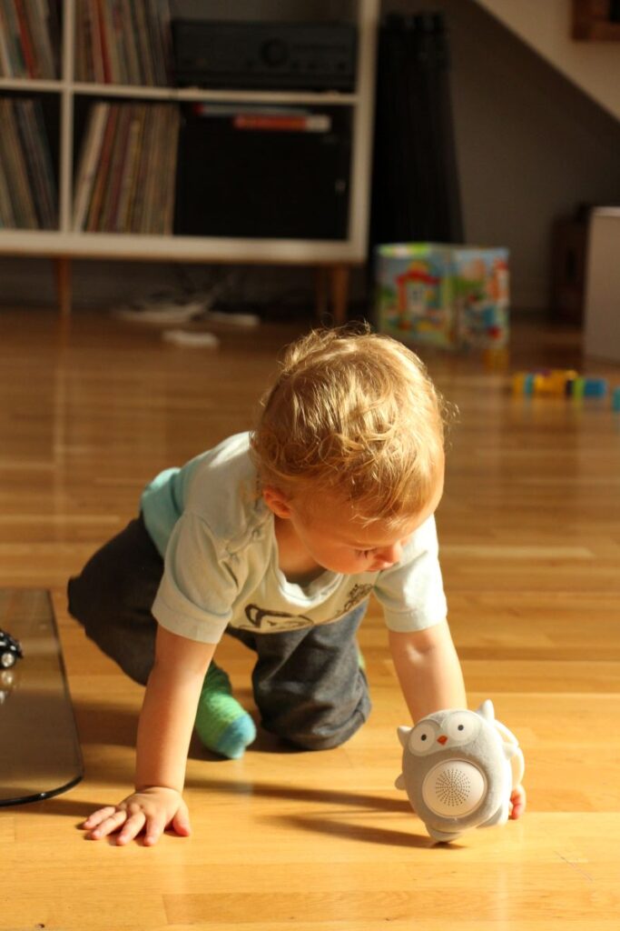 a toddler plays with a Bluetooth speaker and white noise machine while on a family trip to Norway.