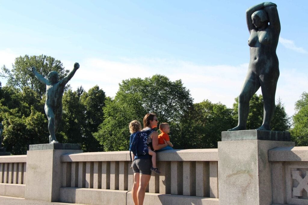 Celine Brewer, owner of FamilyCanTravel.com, admires the statues on a bridge leading into Vigeland Sculpture Park while visiting Oslo with her kids.