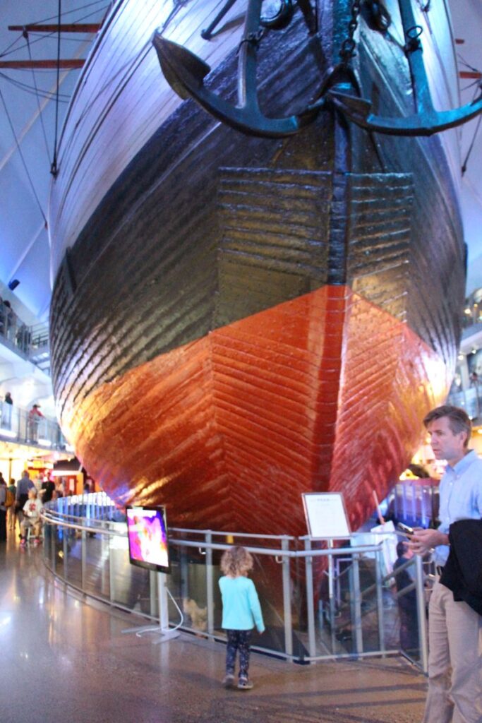 a 4-year old child looks at the giant boat in the Fram Museum in Oslo, Norway.