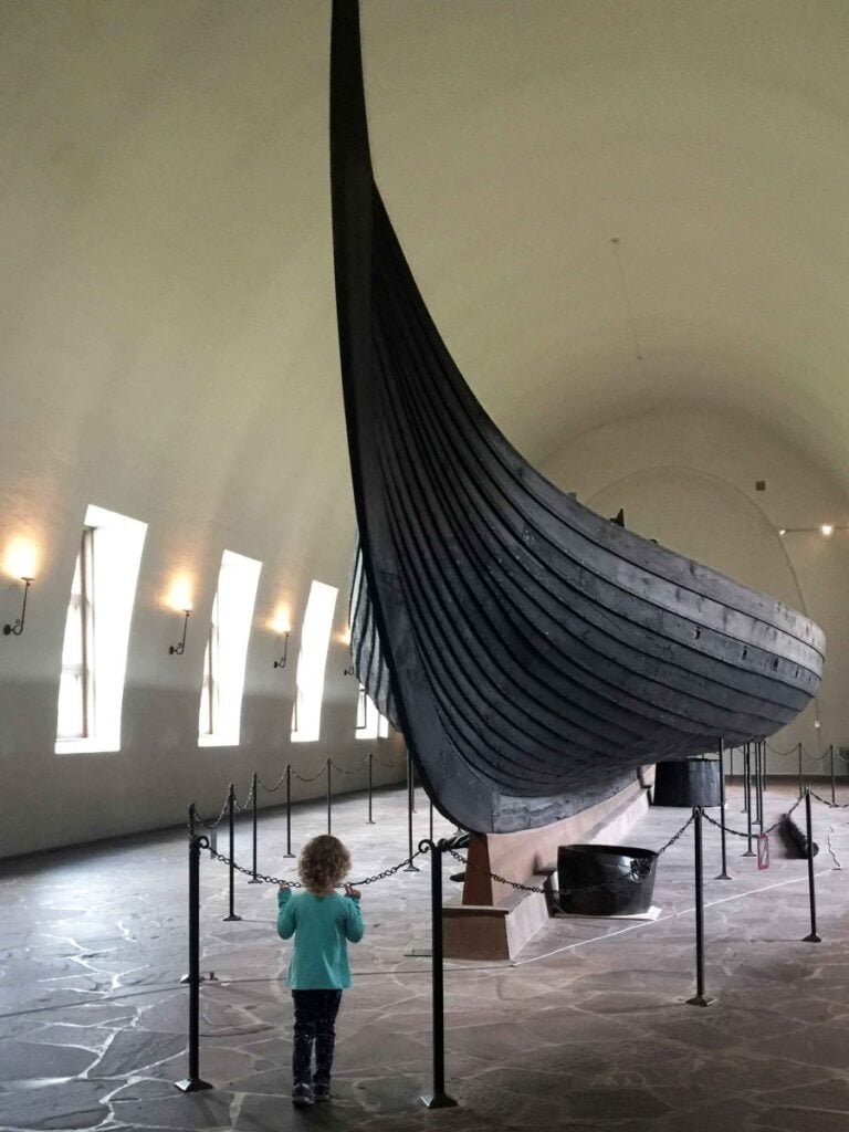 a 4-year old girl looks at a Viking ship at the Museum of the Viking Age in Oslo, Norway.