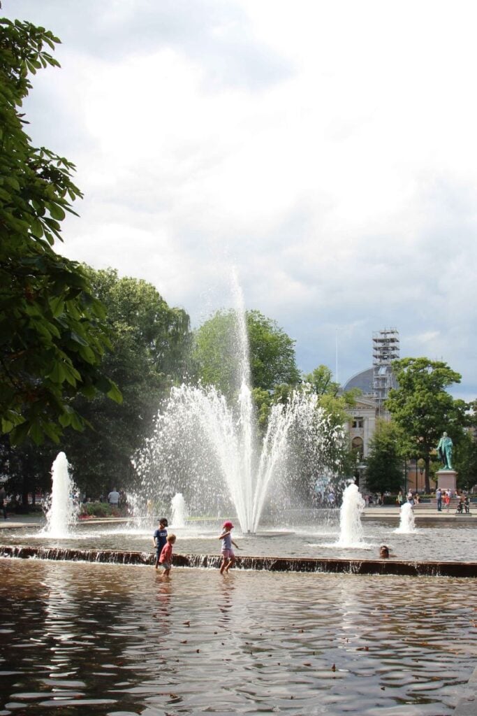 Young kids play in the fountain water at Spikersuppa in Oslo, Norway.