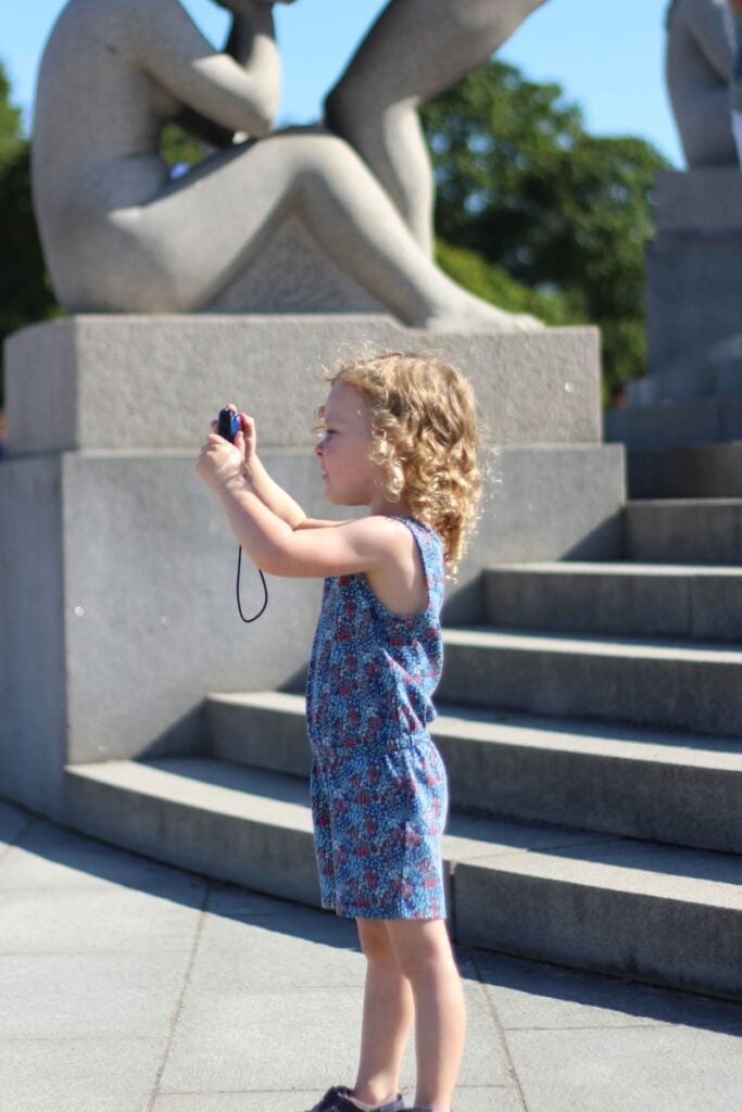 a 4-year old girl gets creative with her own camera while visiting the Vigeland Sculpture Park while on a family vacation to Oslo, Norway.