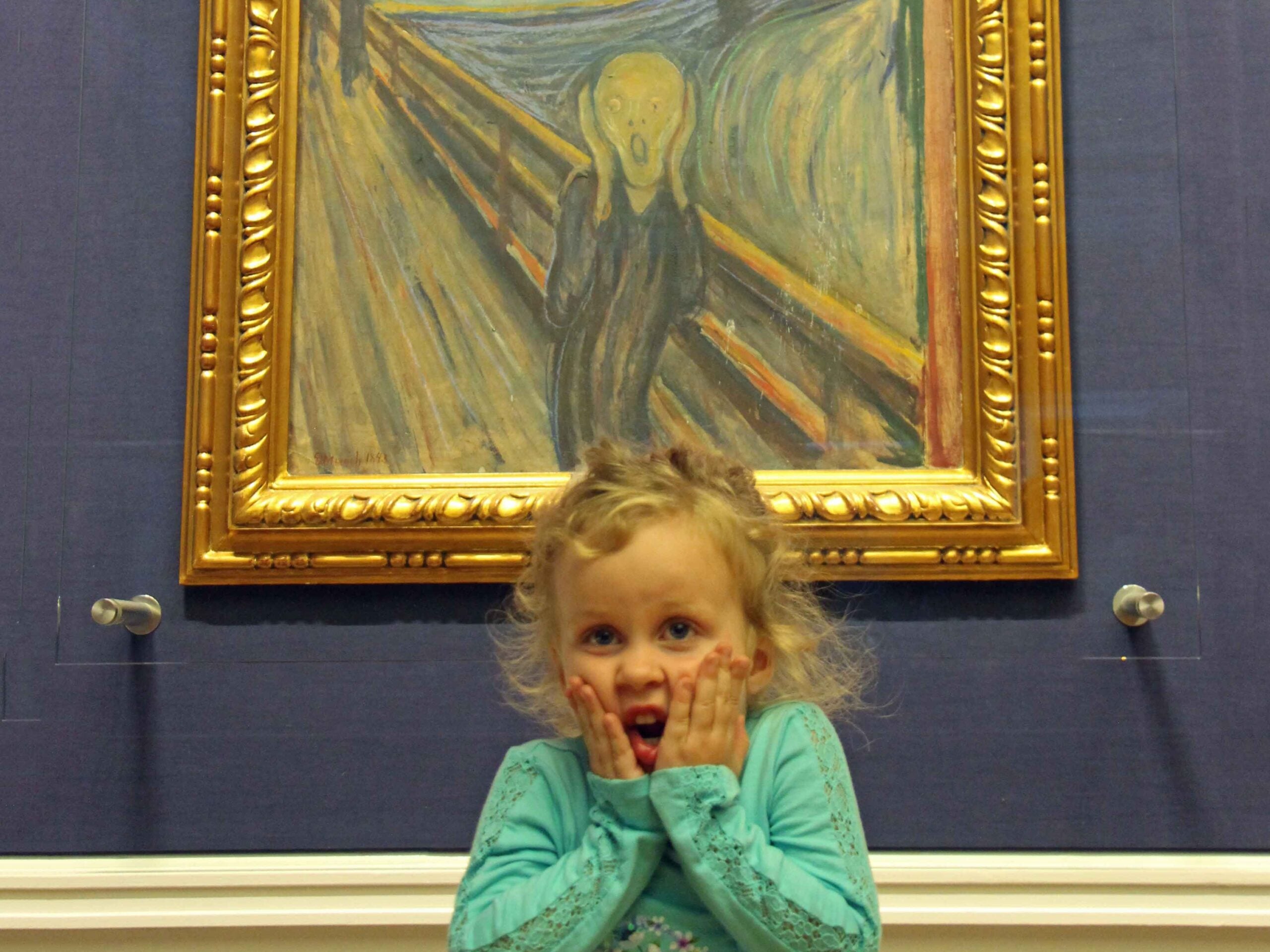 a 4-year old girl on a family trip to Oslo, imitates the famous Scream painting by Edvard Munch.