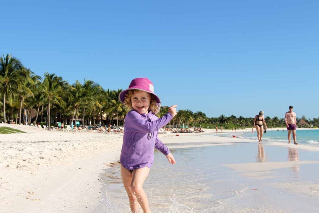 a 4-year old girl on a family holiday to Riviera Maya has fun on Xpu-Ha beach.