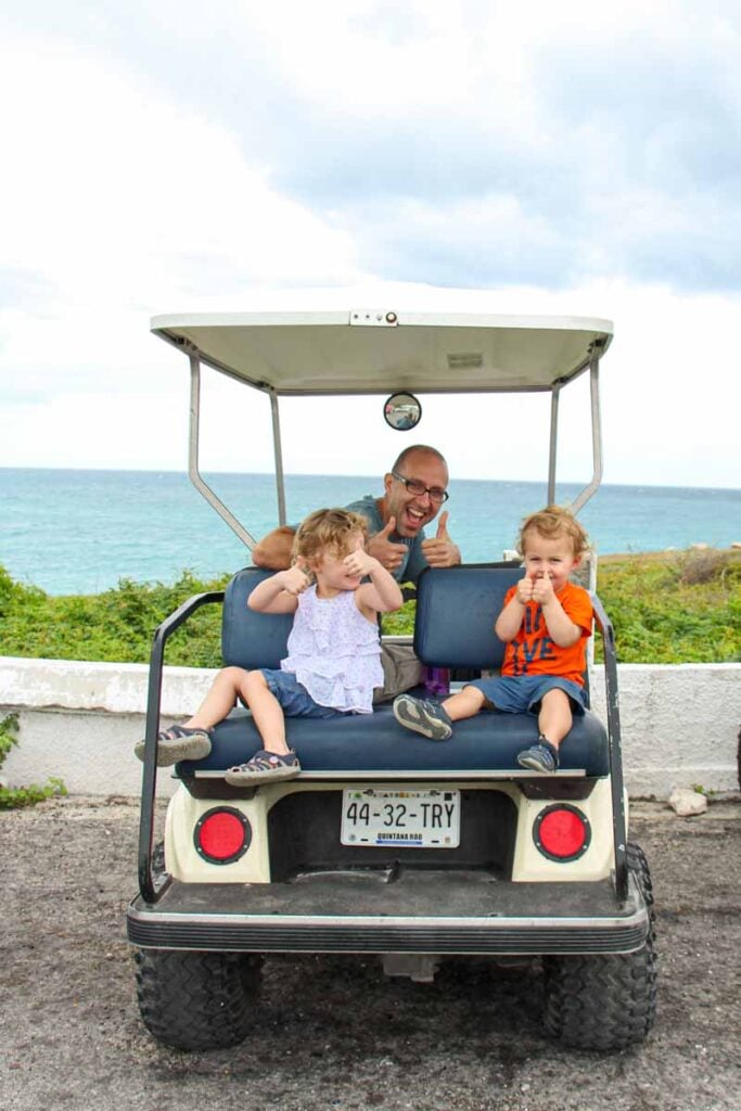 Dan Brewer and his kids sit in a golf cart during a day trip to Isla Mujeres with kids.