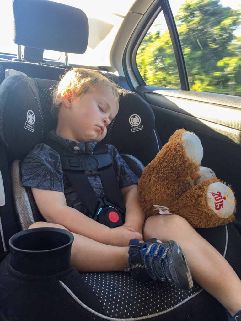 a toddler asleep in a rental car in the Riviera Maya.