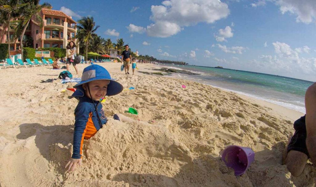 a 2-year old is buried in the sand at a public beach in Playa del Carmen, Mexico.