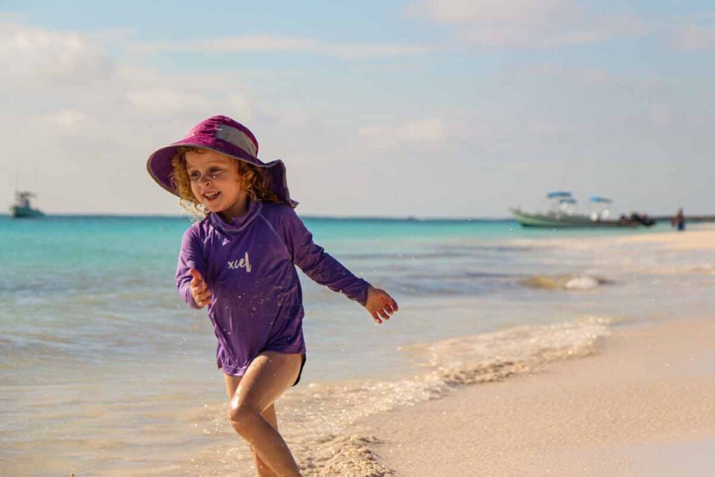 a 4-year old girl on family trip to the Riviera Maya plays in the sand at Xpu-Ha beach near Playa del Carmen.