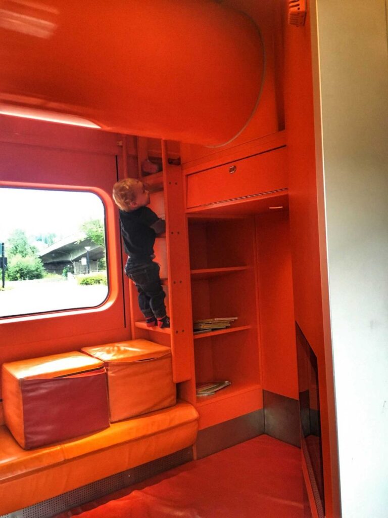 a 2-year old climbs a ladder in the family train car on the Oslo to Bergen train,
