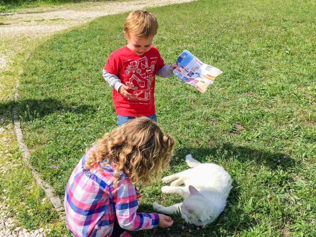 The Brewer kids play with a cat at Memento Park in Budapest, Hungary.