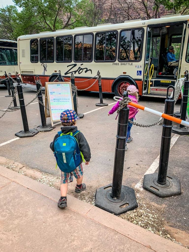 the kids from the Family Can Travel blog board the the Zion National Park shuttle bus at the Visitor Center.
