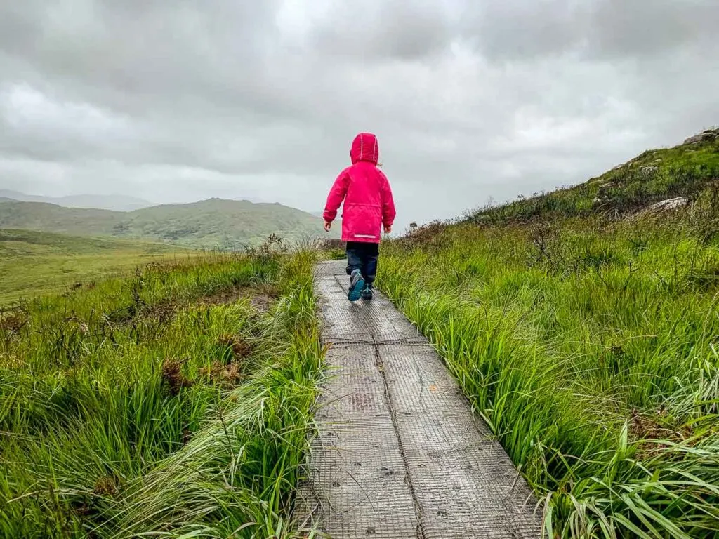 image of girl hiking boardwalks on Torc Mountain hiking trail in Killarney National Park Ireland