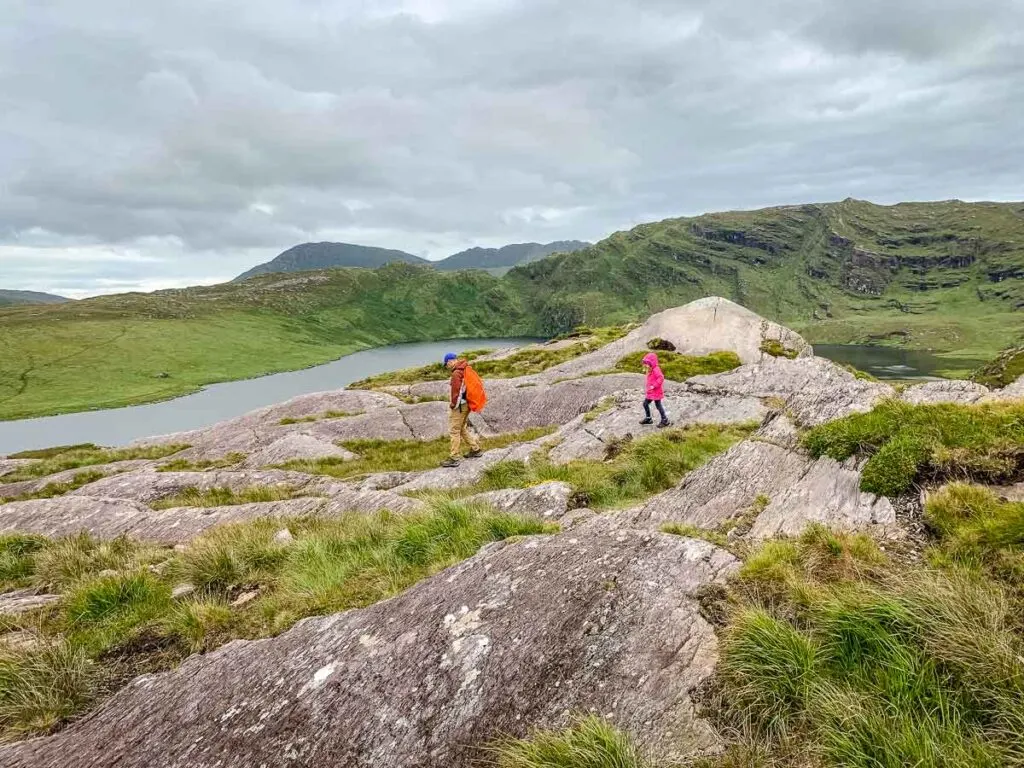 image of father and daughter walking over rocks towards Barley Lake in Ireland