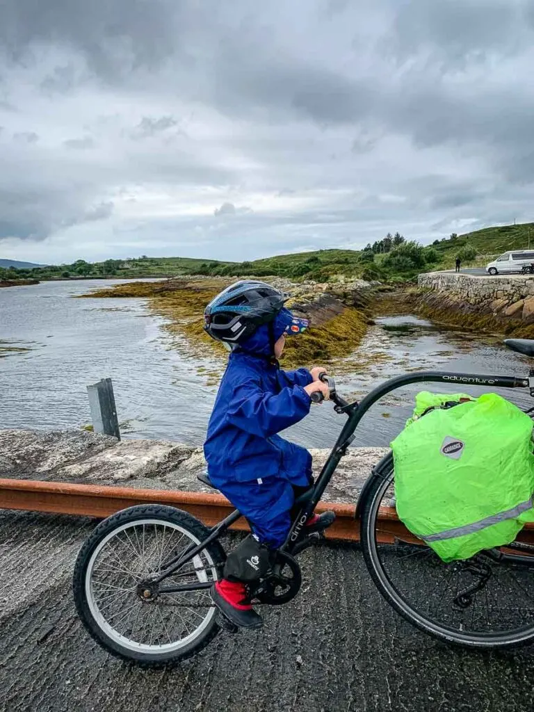 close up image of boy on tag-a-long attached to parents bike