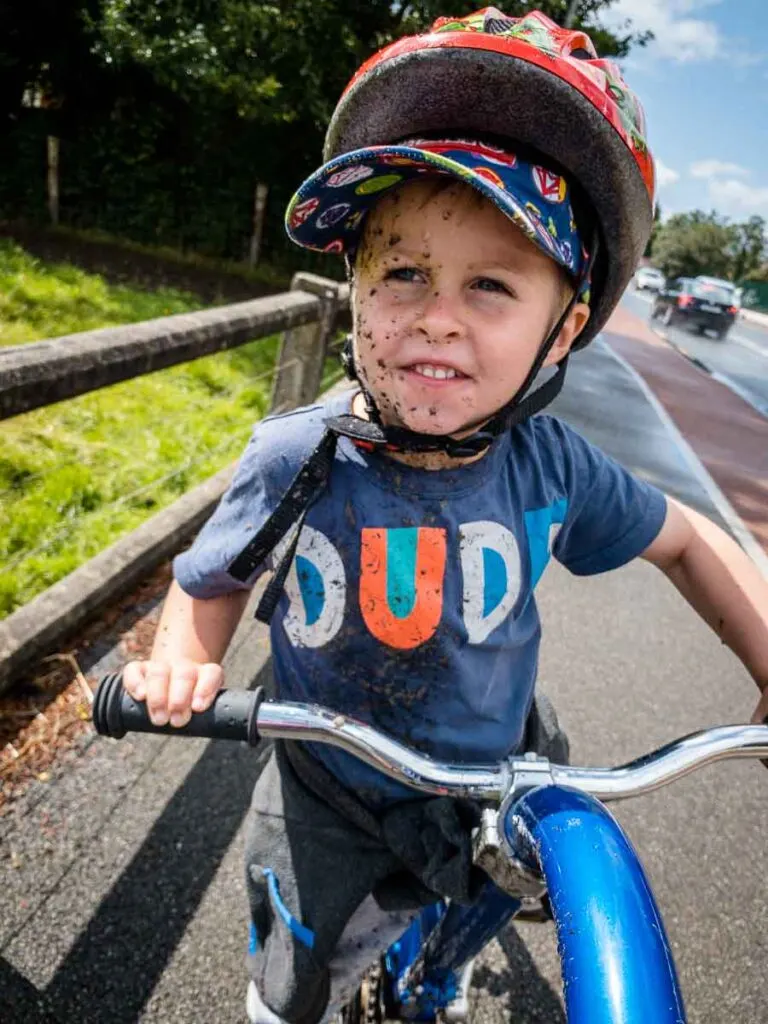 image of child covered in mud on tag-a-long bike