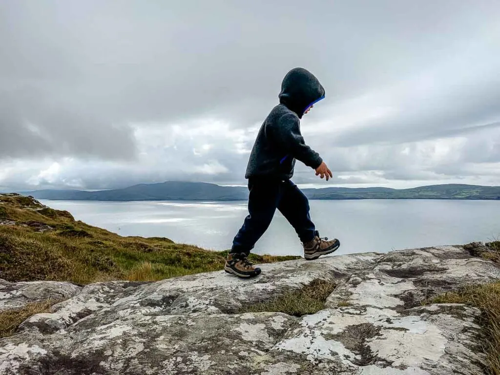 image of boy hiking on rocks on Lighthouse Loop Trail in Ireland