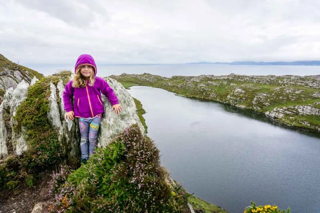 Image of girl in front of lake with ocean in the distance on Lighthouse Loop Hike in Ireland