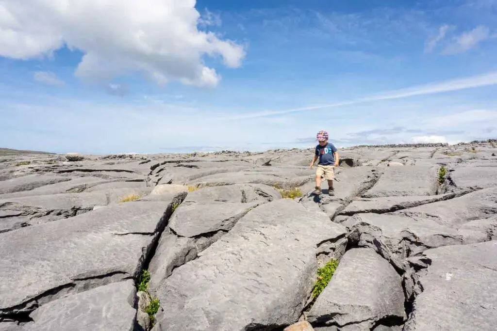 image of boy walking on rock formations on Aran Island Inishmore Ireland