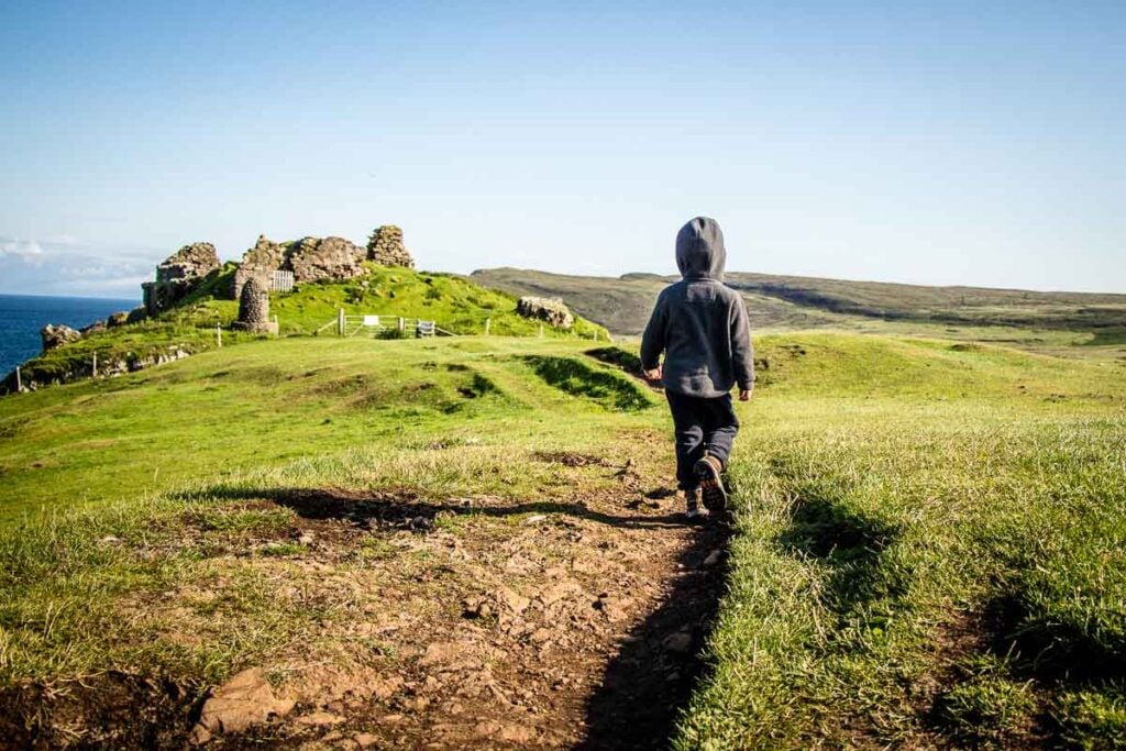 image of boy walking towards Duntulum Castle ruins on Isle of Skye