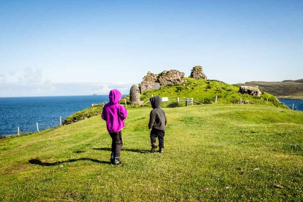 image of two kids walking towards Duntulum Castle Ruins on Isle of Skye