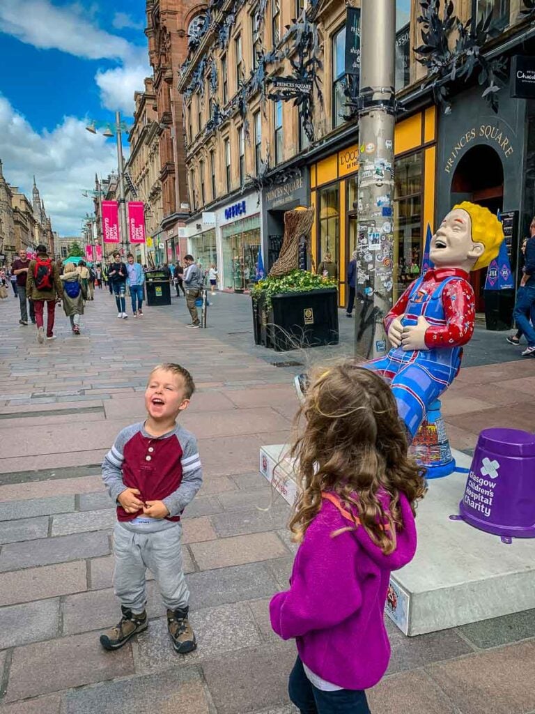 A boy imitates a street statue of Oor Wullie - part of the Oor Wullie's BIG Bucket Trail fundraiser for Scotland's children's hospital charities