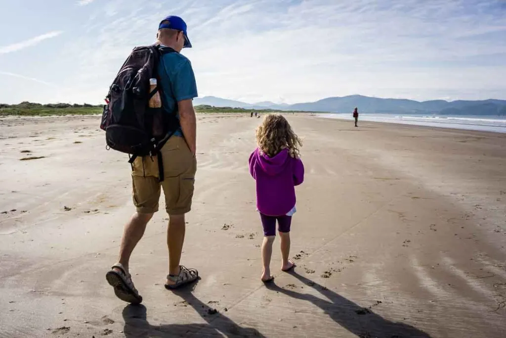 image of father and daughter walking along Inch Beach on Dingle Peninsula Ireland
