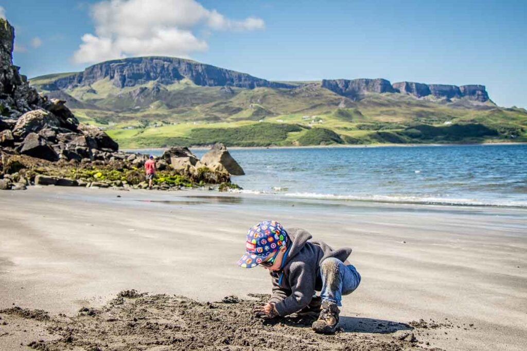 image of boy in grey hoodie and cap playing on Slipaway Beach on Isle of Skye