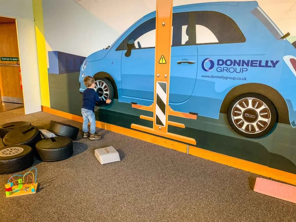 image of boy putting a play tire on a car at W5 in Belfast with Kids