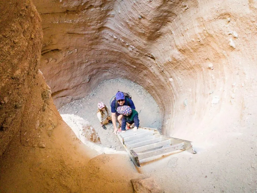 image of boy climbing ladder along ladder canyon trail - palm springs hiking
