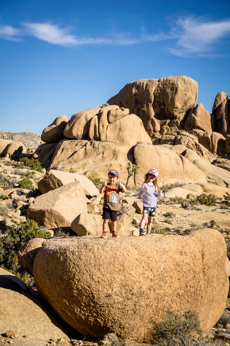 image of two kids along Split Rock, one of the best hikes in Joshua Tree with kids