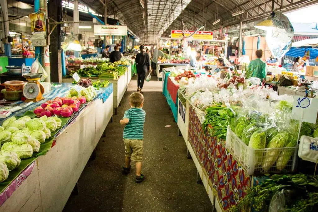 A child explores a food market in Chiang Mai, Thailand