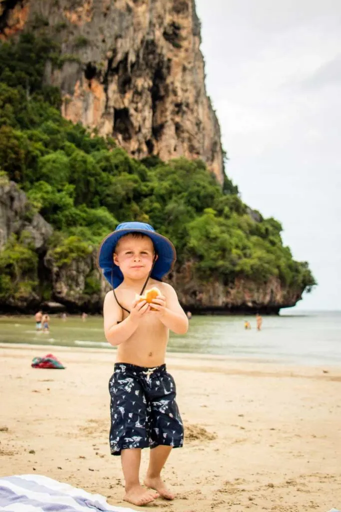 A child enjoying a sandwich at Railay Beach, Thailand