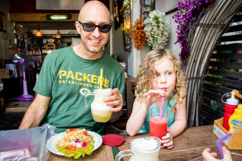 enjoying papaya salad and fruit smoothies for a Thai lunch