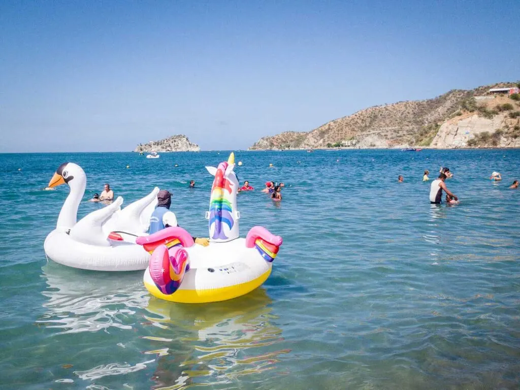 A vendor tries to rent an inflatable unicorn and a swan at Playa el Rodadero, Colombia