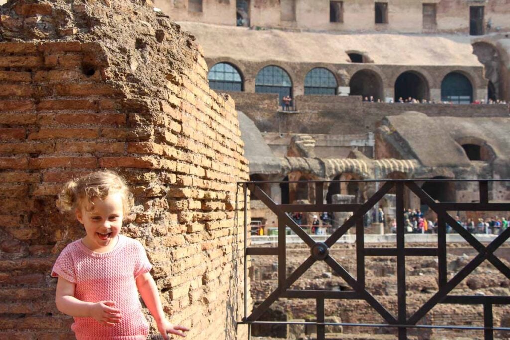 A 3-year old girl on a family trip to Italy has a giggle at the Roman Colosseum.