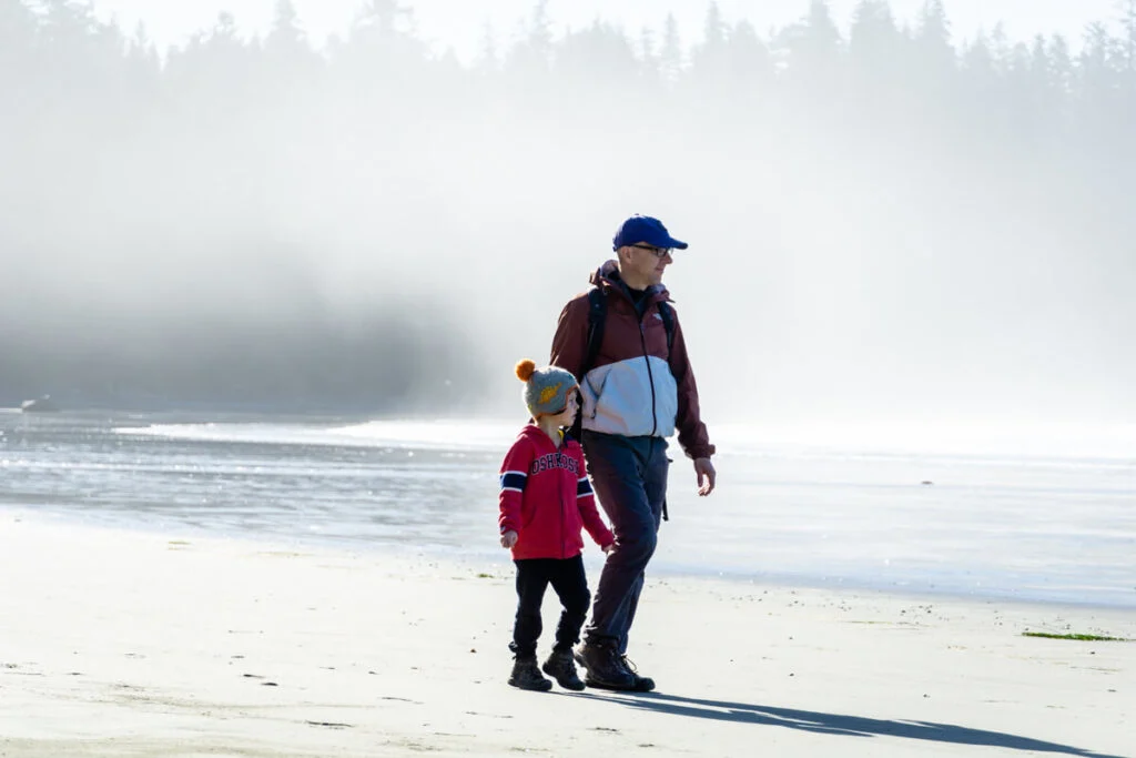 Family walks along the beach near Tofino, BC