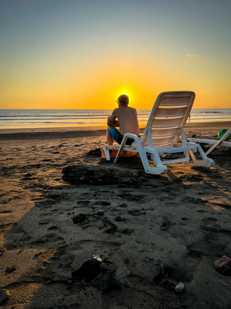the setting sun silhouettes a mans head at the beach near the Jaco Beach Best Western Resort