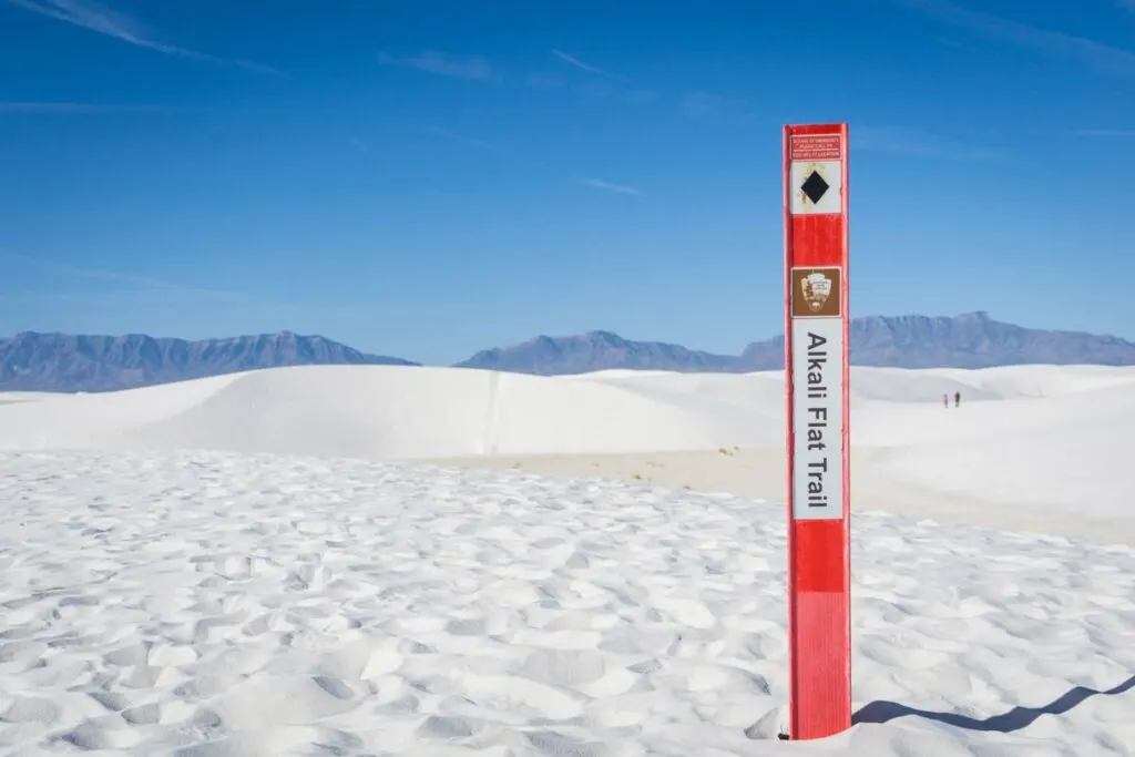 a bright orange trail marker shows the hiking path on the Alkali Trail.