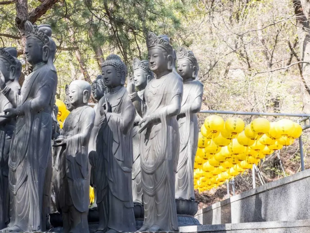 row of Buddha statues greet hikers at the Cheonchuksa Temple on one of the best hikes near Seoul.