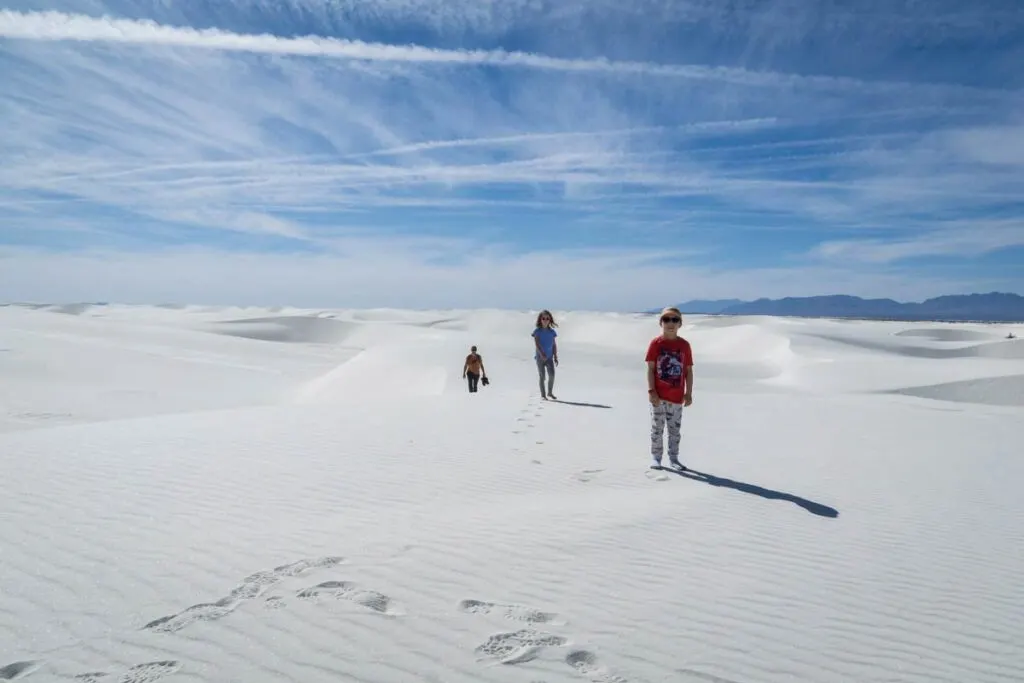 a family enjoys a hike on the Alkali Trail through miles of beautiful white sand dunes.