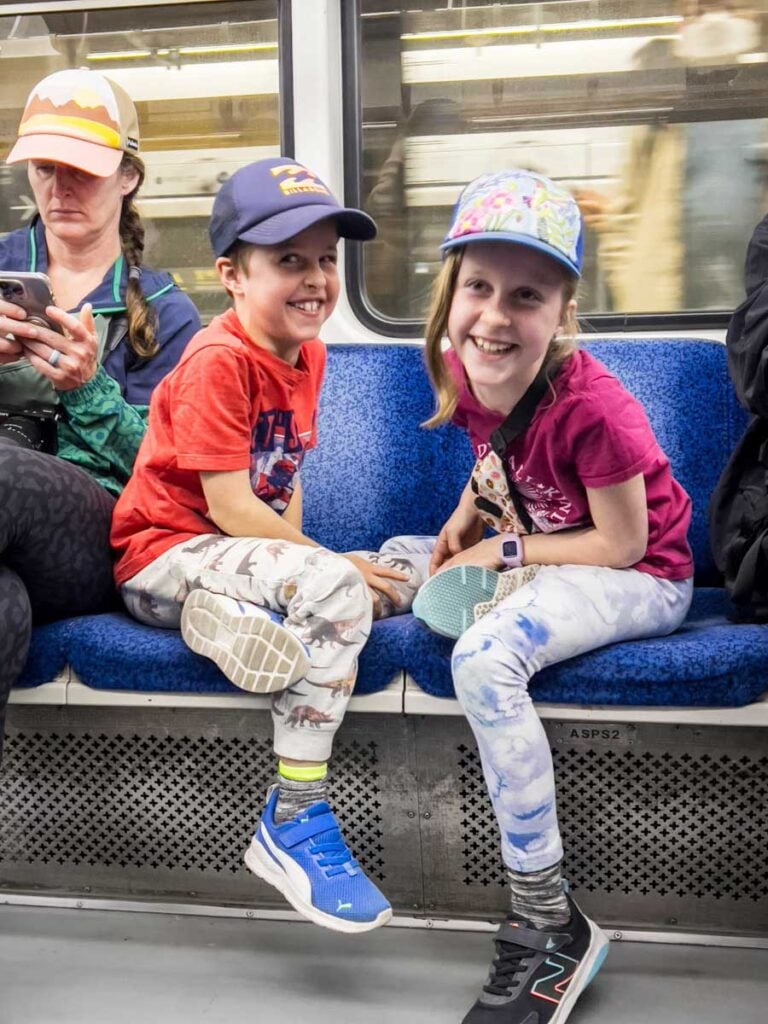 two kids enjoy a good laugh while riding the subway in Seoul, Korea.