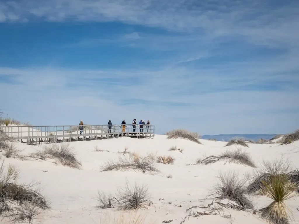 Visitors to the White Sands National Park enjoy the views at the end of the Interdune Boardwalk.